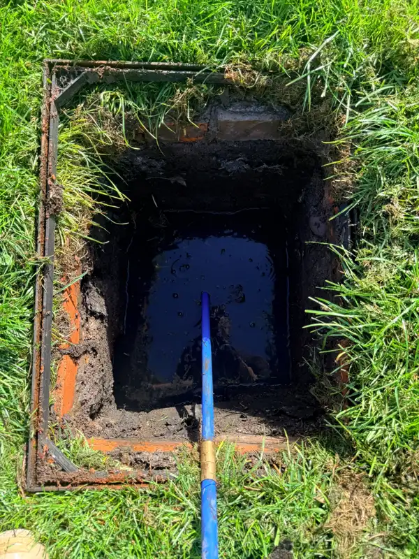 Drain-clearing rod in an open brick drainage chamber