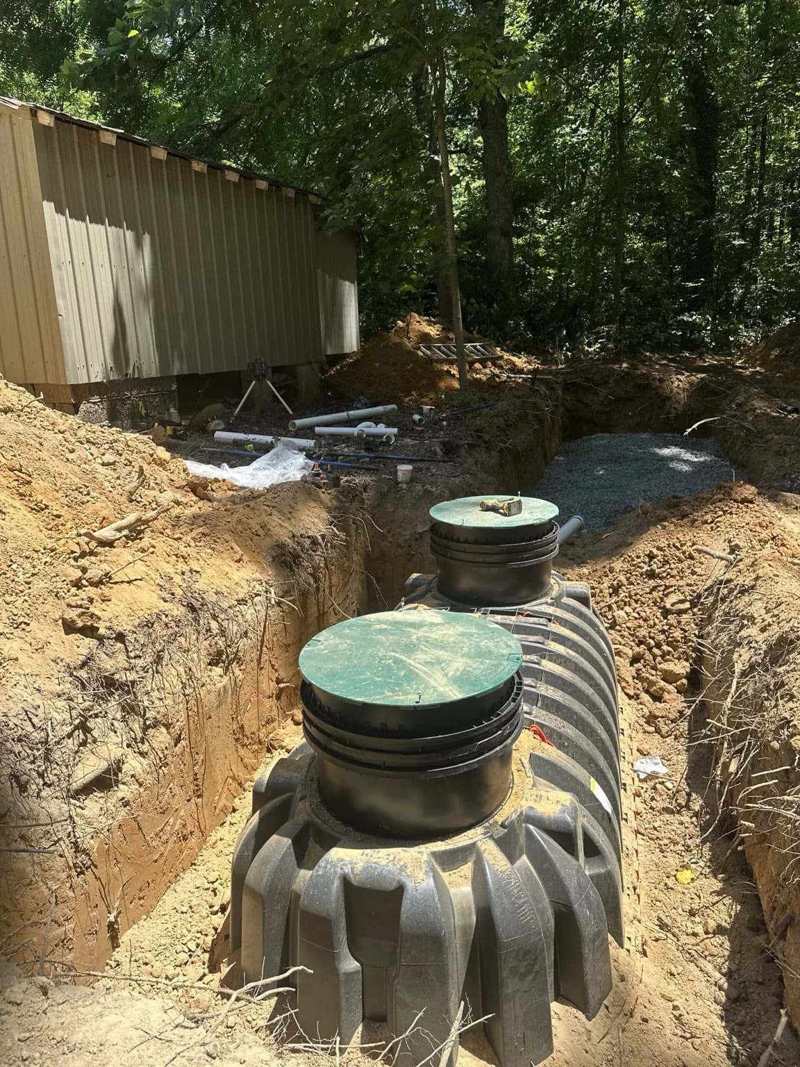 Underground tank positioned in an excavation with two access covers